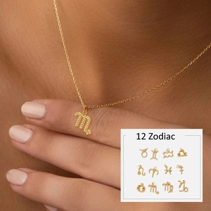 Detailed close-up of 12 gold zodiac pendants featuring sparkling micro-pave cubic zirconia
