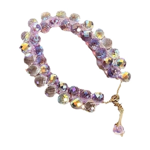 Kids purple faceted crystal bead bracelet with gold chain and tassel on white background