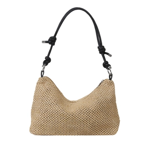Woven straw tote bag with black leather handles and decorative knots on white background
