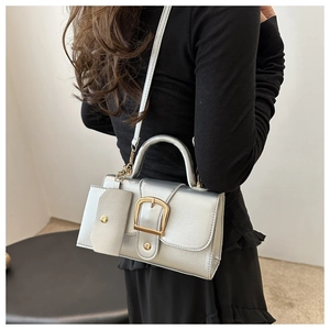 Silver PU leather shoulder bag featuring golden metal buckles and a mini coin purse charm
