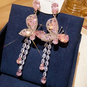 Macro view of crystal butterfly earrings with pink accents and waterfall fringe