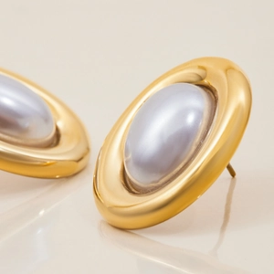 Macro detail of 18K gold stainless steel earrings with elegant grey oval pearls