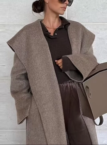 Close-up of elegant brown wool coat with wide lapels and belted waist styling
