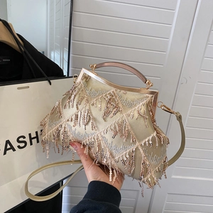 Close-up of golden evening bag featuring sequin tassels and elegant diamond lattice texture