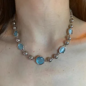 Minimalist chain necklace with blue crystals and silver beads worn on the neck