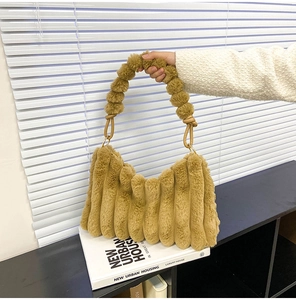 Detail of khaki plush tote bag featuring soft striped fur and pom-pom handle decoration