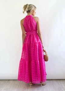 Detail of rose pink halter maxi dress featuring layered tier hem and checkered texture