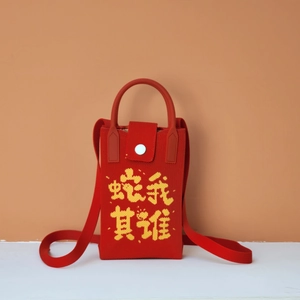 Detail of red knitted crossbody phone bag with yellow woven Chinese characters and snap button