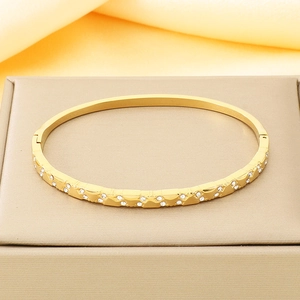 Detailed macro of a gold-plated stainless steel hinge bracelet with sparkling zircon stones