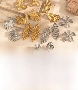 Detailed view of floral and geometric titanium steel earrings in gold and silver finish