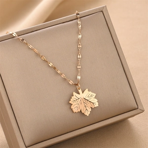 Collar con colgante de hoja de membrillo en oro rosa sobre una caja de joyas elegante