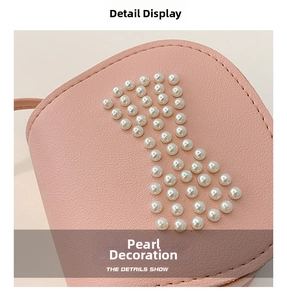 Detail shot of synthetic pink leather bag featuring delicate white pearl embellishments