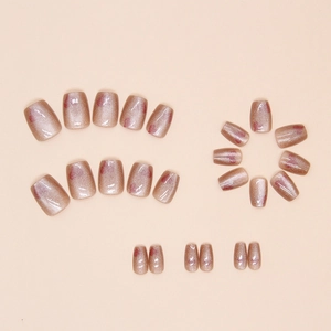 Macro detail of champagne cat-eye press-on nails with red heart patterns and glitter finish