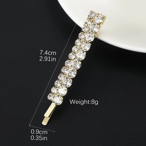 Detail view of golden hair clip with crystal rhinestones showing dimensions 7.4cm by 0.9cm
