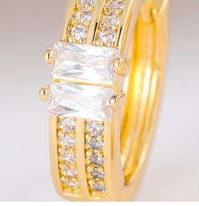 Macro view of gold hoop earrings featuring dual rectangular zircons and pavé setting