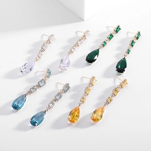 Detail of elegant teardrop earrings with colorful zircon stones in white, green, and blue