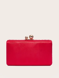 Detail of red satin evening clutch bag featuring a gold double ball metal clasp closure