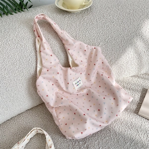 Close-up of floral tote bag fabric with sozakka beauté label on soft fleece texture
