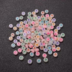 Detailed macro view of multi-colored translucent round heart beads on black texture