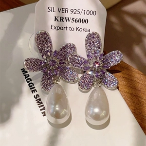 Detail of 925 silver flower earrings with purple rhinestones and white teardrop pearls