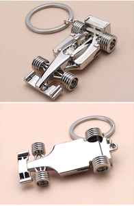 Detailed close-up showing the metallic underside and top view of an F1 race car keychain