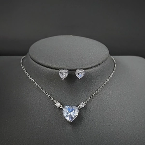 Elegant silver heart-shaped crystal necklace and earring set on professional display
