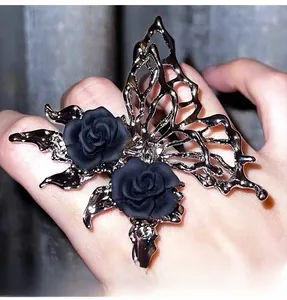 Macro shot of liquid metal butterfly ring with black roses and gothic open design
