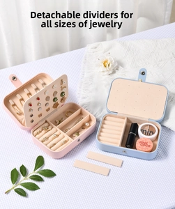Pink and blue leather jewelry box with compartments on white knit background