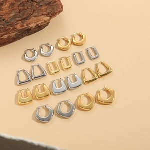 Collection of geometric gold and silver hoop earrings on a natural textured background