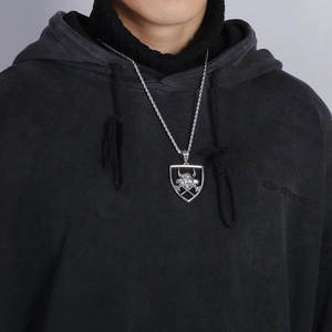 Détail du pendentif bouclier viking avec tête de taureau et haches sur collier en acier
