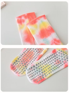 Detail of tie-dye yoga socks with ribbed cuffs and grey non-slip silicone dots on soles