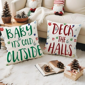 Close-up of linen Christmas pillow covers with festive lettering on a cozy white rug