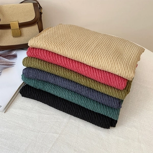 Linen cotton scarfs in multiple colors with waffle texture displayed on a white table