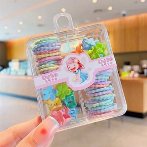 Close-up of kids hair accessories set in a cute box with macaron ties and flower clips