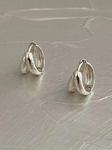 Macro detail of geometric double hoop sterling silver earrings in polished finish