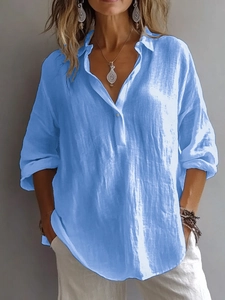 Détail de chemise en lin bleu clair avec col en V, montrant la texture du tissu et la coupe