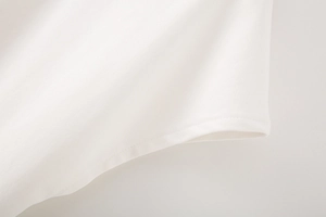 Gros plan sur un t-shirt blanc avec coutures soignées et détails de dentelle texturée