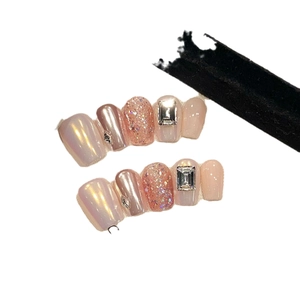 Short square press-on nails with aurora pink glitter and rhinestone accents