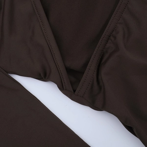 Gros plan détaillé du tissu tricoté marron foncé avec coutures et texture élastique