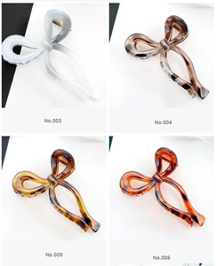 Detail display of butterfly hair clips in marble and tortoiseshell resin patterns