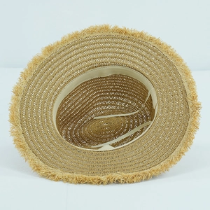 Detail of woven straw sun hat showing inner adjustable sweatband and raw fringe brim edge