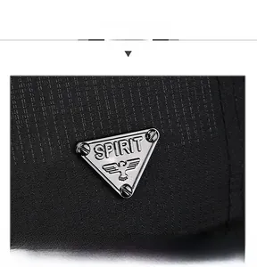 Macro shot of triangle metal logo with eagle crest on textured black fabric cap