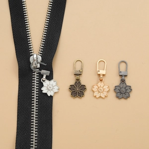 Macro shot of sakura-shaped metal zipper pulls in four colors for DIY garment repair