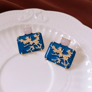 Detailed view of vintage enamel floral earrings with blue base and pink gemstones