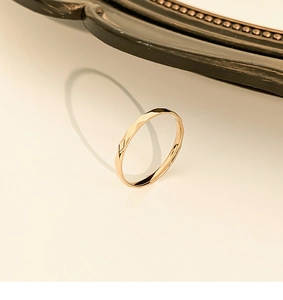 Detailed view of faceted gold titanium steel ring with sparkling geometric surface