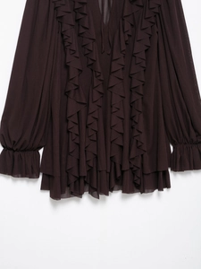 Detail der Rüschen und Laternenärmel an einem dunkelbraunen Chiffon-Urlaubskleid
