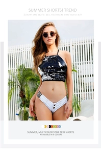 Detail der weißen Low-Rise Denim-Shorts mit Fransensaum und Metallknöpfen am Model