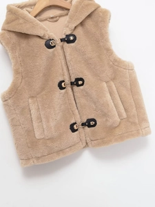 Detail of khaki faux fur hooded vest with black leather buckles and golden metal clasps