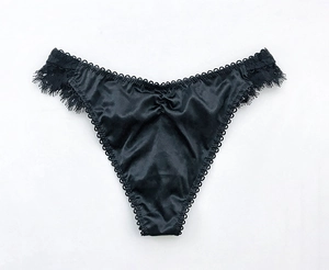 Dettaglio dell'elegante pizzo nero e del tessuto in raso per perizoma sexy da donna