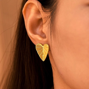 Minimalist gold heart leaf earrings in stainless steel worn for side profile view